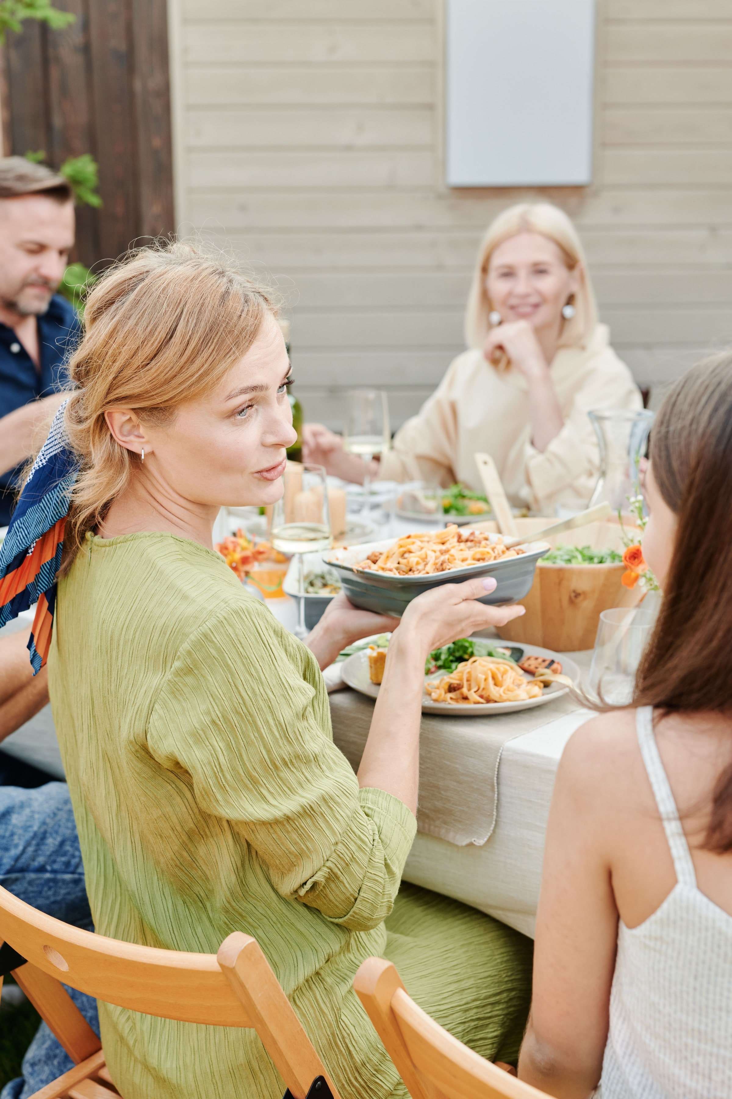 Des amis et de la famille se partagent un repas en plein air